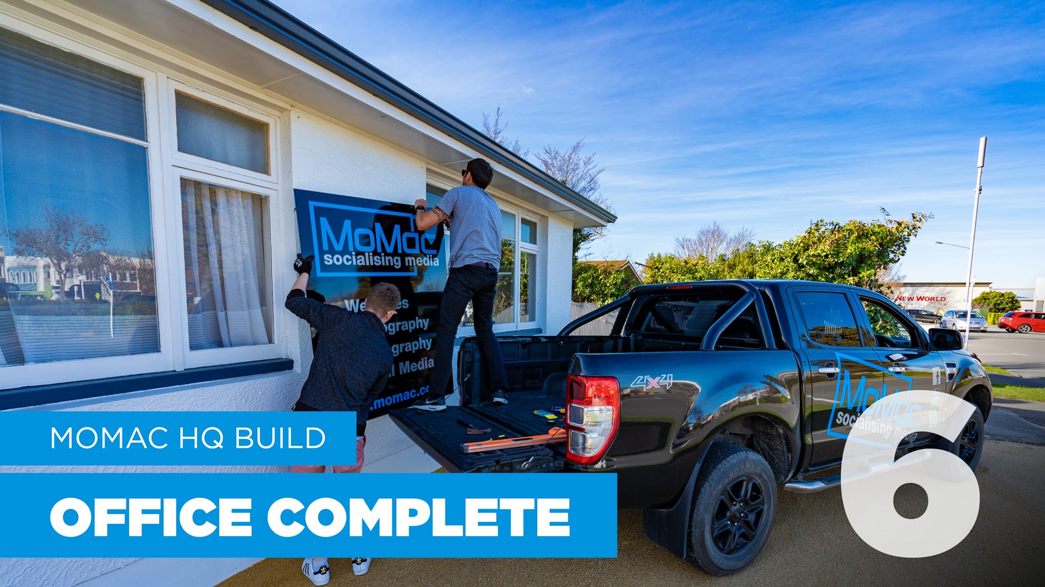 MoMac creative agency team putting up a sign on their office in Rangiora