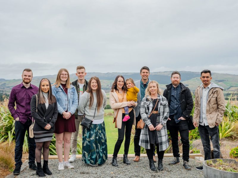 MoMac creative agency team at Waipara House of Ball winery in front of mountain scenery