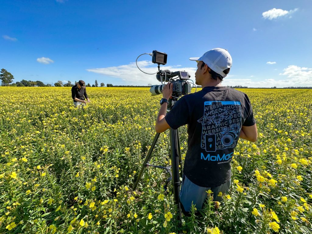 A MoMac videographer filming a company in a flower field in Christchurch
